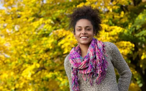 Smiling young woman standing outside happy that dental sedation can releive her dental anxiety