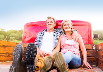 senior couple sitting in truck bed