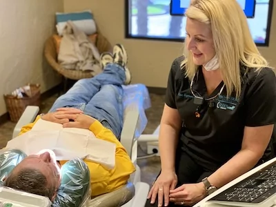 Vaca and Kirby dental team member talking with a patient during a dental check-up in Longview, TX