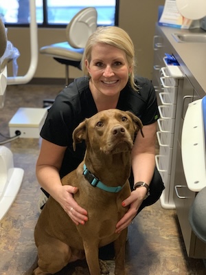 Vaca and Kirby Dental team member posing for a photo with a dog