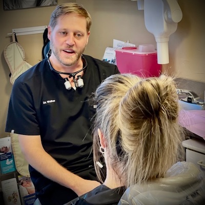 Dr. Walker talking with a patient during  dental checkup and exam in Longiew