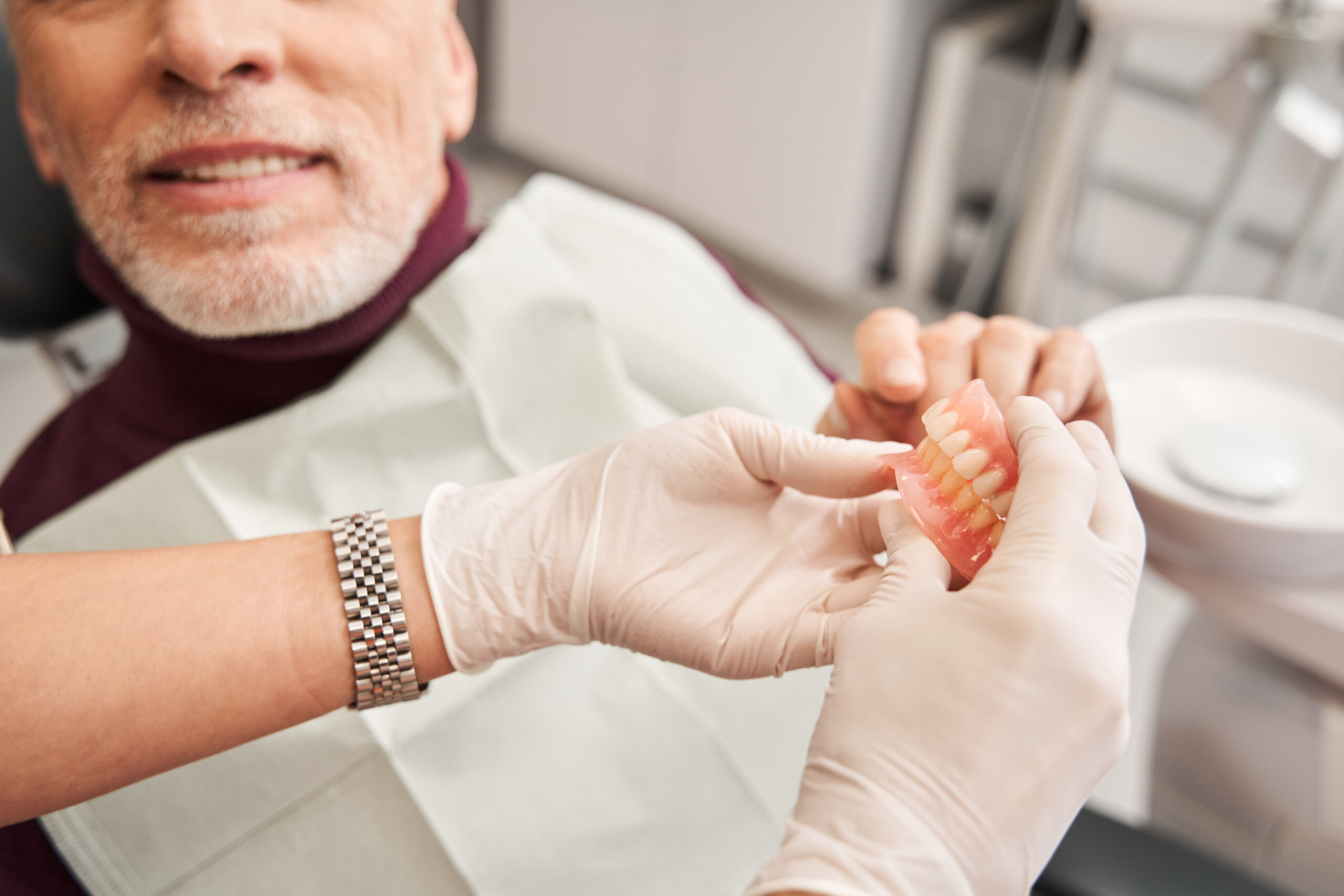 doctor showing a patient a pair of dentures