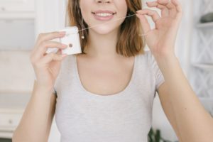 Woman pulling out dental floss